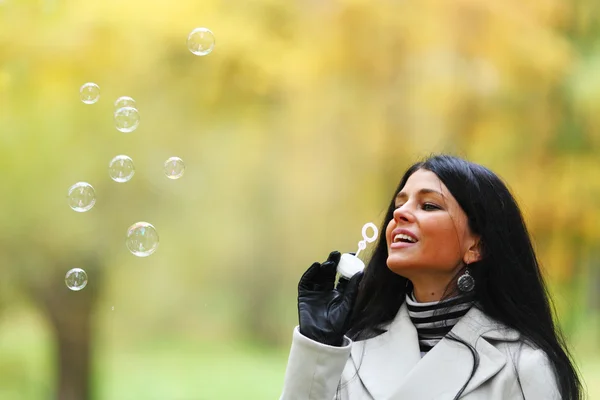 Осінь жінка дме бульбашки — стокове фото