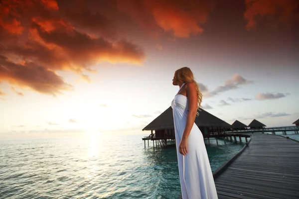 Femme en robe sur le coucher du soleil maldivien — Photo