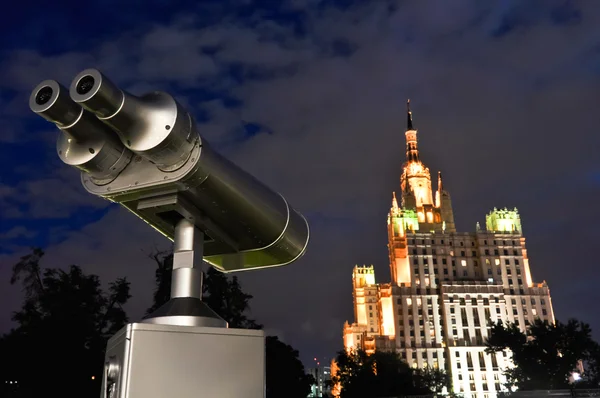 Beobachtungsteleskop am dunklen Himmel blickt auf ein hohes Gebäude — Stockfoto