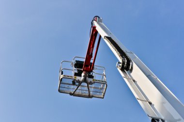 White hydraulic construction cradle against the blue sky clipart