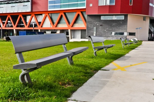 Современная скамейка на зеленой лужайке — стоковое фото