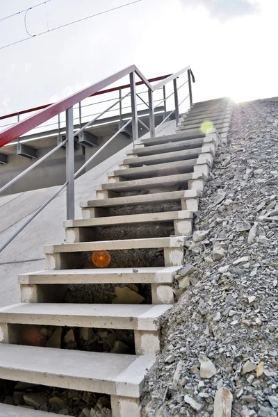Escalier en béton avec une main courante métallique sur le remblai de gravier — Photo