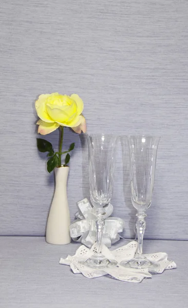 Två glas glas på en narkin och en gul ros — Stockfoto
