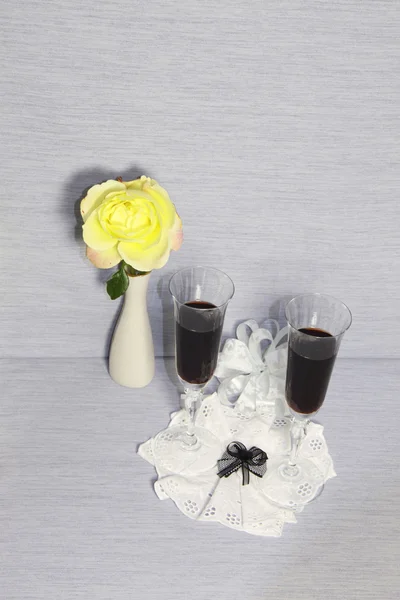 Δύο γυάλινα ποτήρια με κρασί και ένα κίτρινο τριαντάφυλλο — Φωτογραφία Αρχείου