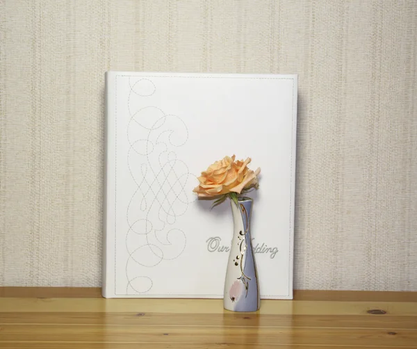 The photograph album and a peach rose on a wooden table — Stock Photo, Image