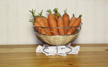 Carrots in a vase on a wooden table