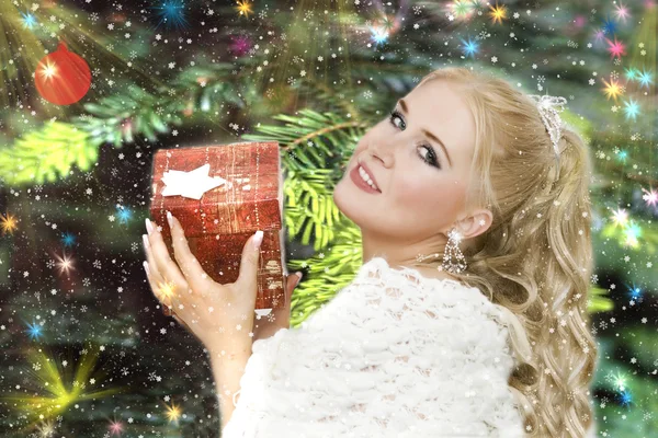 Vackra leende flicka med en julklapp — Stockfoto