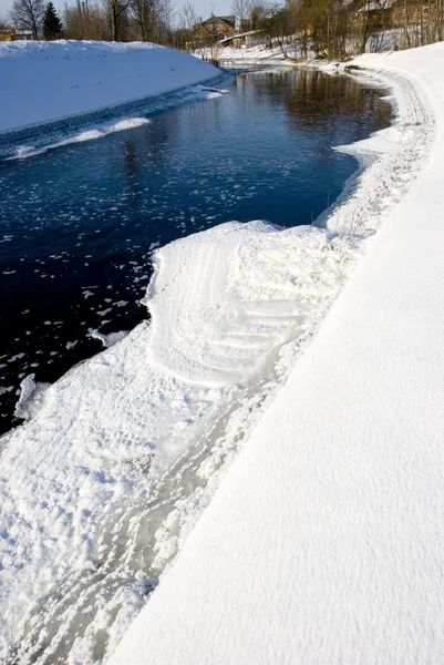 Rivière en hiver et passage de morceaux de glace et de maisons rurales . — Photo