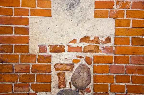 Fragment of ancient red brick wall with stones ant cement in it. — Stock Photo, Image