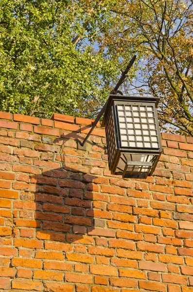 Starożytne reflektorem montowane na czerwony mur z cegły. Oldtown szczegóły. — Zdjęcie stockowe