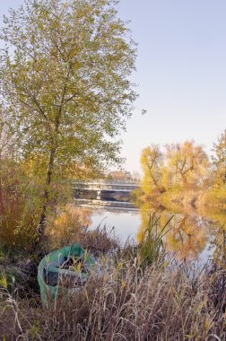 Wooden boat locked near river. Autumn morning view clipart