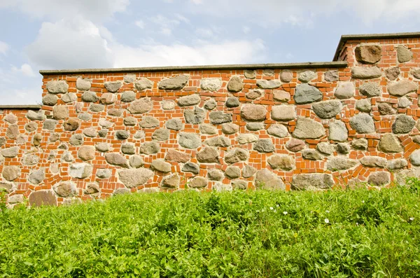 Restored ancient wall made of red brick and stones. — Stock Photo, Image