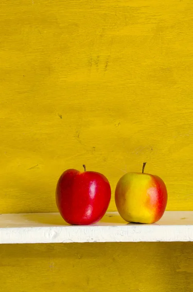 Appels op witte schorten geel muur achtergrond. — Stockfoto