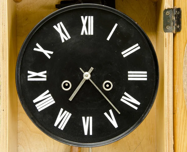 Alte schwarze Uhr mit römischen Ziffern und Pfeilen. — Stockfoto