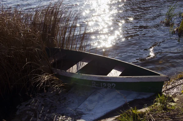 Ξύλινο σκάφος με αριθμό σε το κλειδωμένο στην ακτή της λίμνης — Φωτογραφία Αρχείου