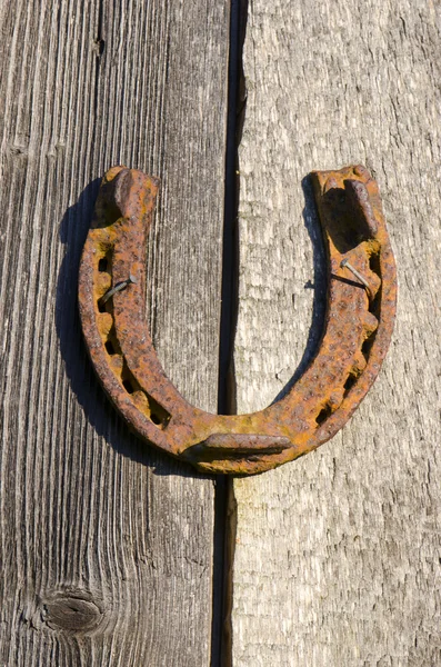 Ferro di cavallo arrugginito inchiodato al vecchio muro. Segno di fortuna . — Foto Stock