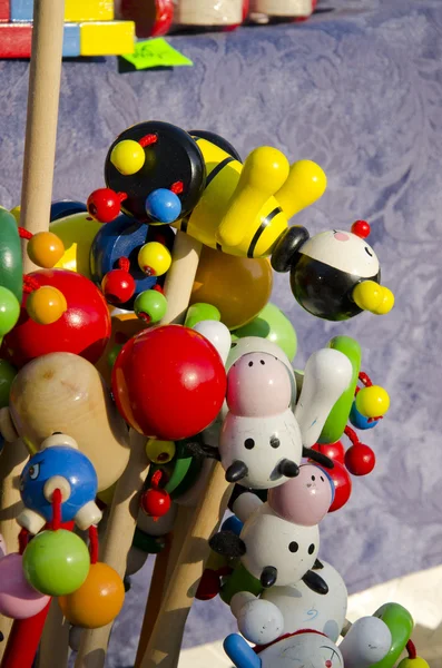 Brinquedos de madeira em um pau vendido na feira ao ar livre . — Fotografia de Stock