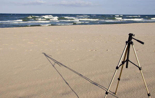 Fotoaparát stativ stojící v seasand. — Stock fotografie