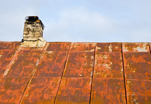 Roestige dak tin en bouwvallige baksteen schoorsteen. — Stockfoto