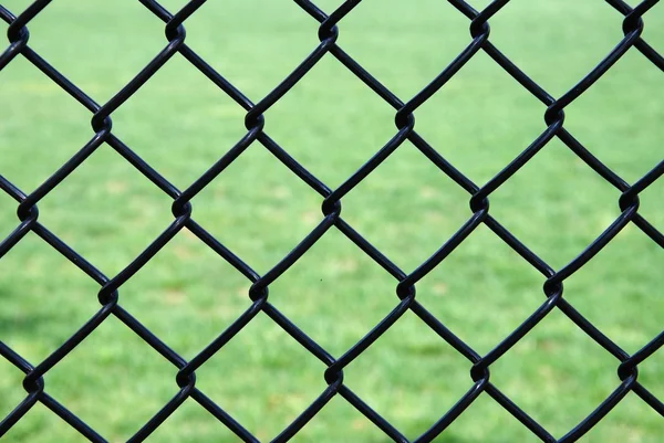 Järn tråd stängsel isolerad på grön bakgrund — Stockfoto