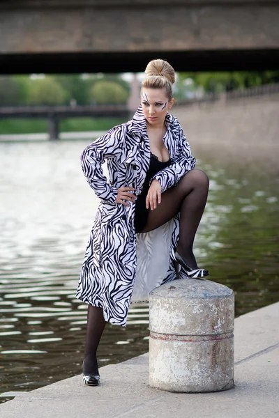 Mooie vrouw poseren aan de waterkant — Stockfoto