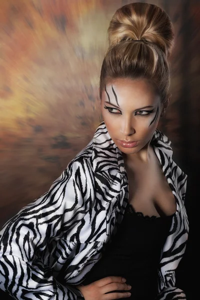 Beautiful woman posing in studio in zebra coat — Stock Photo, Image