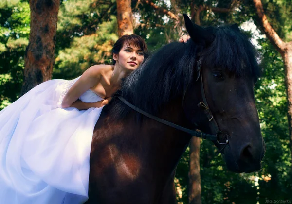 Невеста позирует на лошади — стоковое фото