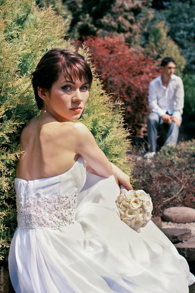 Braut und Bräutigam posieren im Garten — Stockfoto
