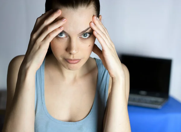 stock image Tired girl on the background of an open laptop