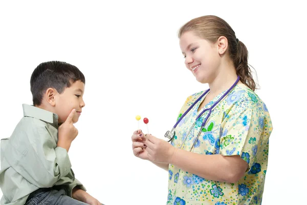 Enfermeira dá ao menino uma escolha de doces . — Fotografia de Stock
