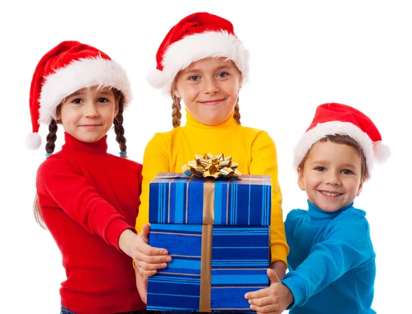 Três crianças sorridentes com presente de Natal — Fotografia de Stock