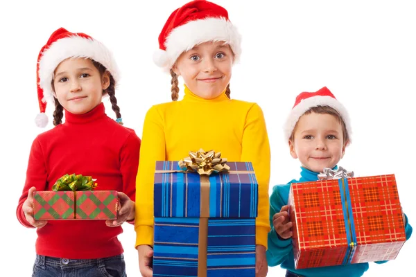 Três crianças sorridentes com caixas de presente de Natal — Fotografia de Stock