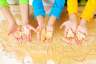 Child's hands with dough over the table clipart