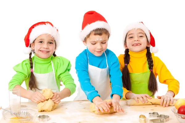 Trzy uśmiechający się dzieci z Boże Narodzenie gotowanie — Zdjęcie stockowe