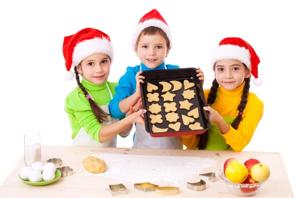 Tre bambini sorridenti con cucina natalizia — Foto Stock