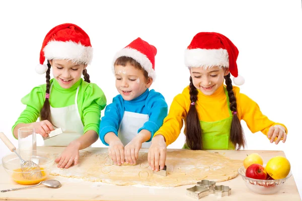 Трое улыбающихся детей с рождественской кухней — стоковое фото