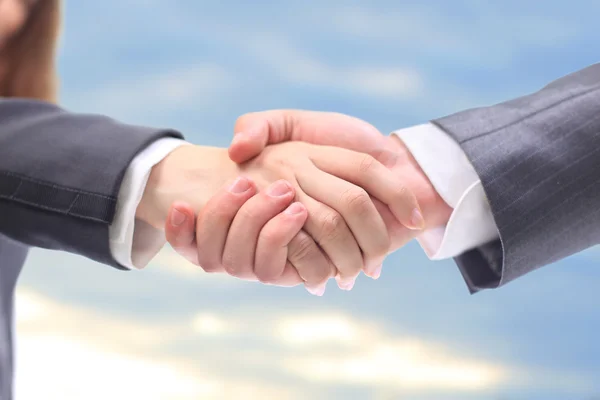 Handshake in the blue sky — Stock Photo, Image