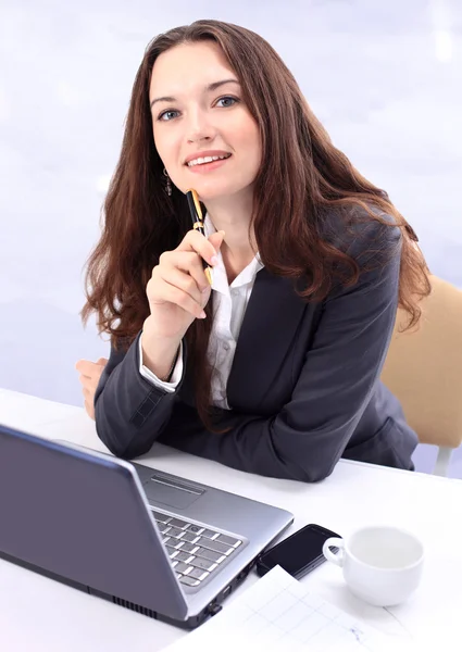 Aantrekkelijke jonge zakenvrouw bezig met laptop in heldere kantoor — Stockfoto