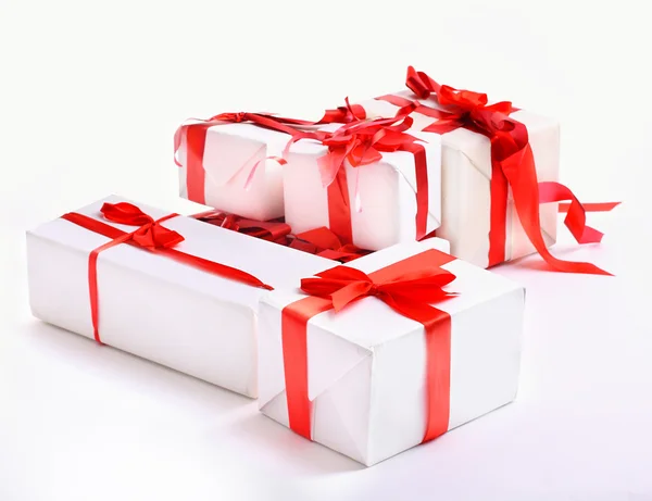 Beyaz yay ile süslenmiş kırmızı hediye kutuları yığını — Stok fotoğraf