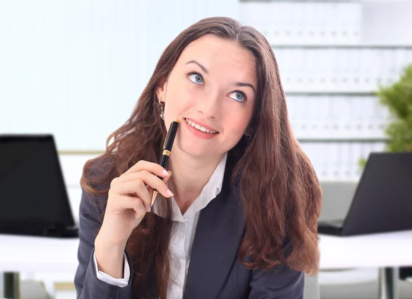 Geschäftsfrau sitzt im Büro und blickt nachdenklich in die Richtung o — Stockfoto