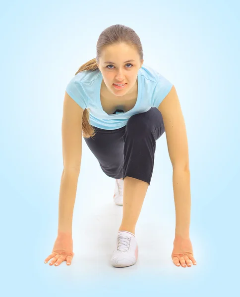 Eine schöne junge Frau beim Sport auf blauem Hintergrund — Stockfoto