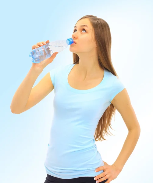 Een mooie jonge vrouw om te drinken het water op een blauwe achtergrond — Stockfoto
