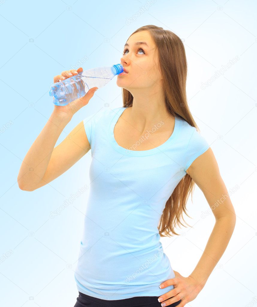 A beautiful young woman to drink the water on a blue background