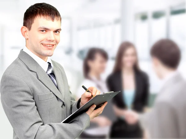 Portrait of confident business man holding document with team in — Stok fotoğraf