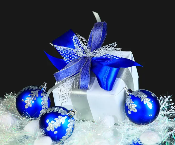 Festive balls with gift box on snow — Stock Photo, Image