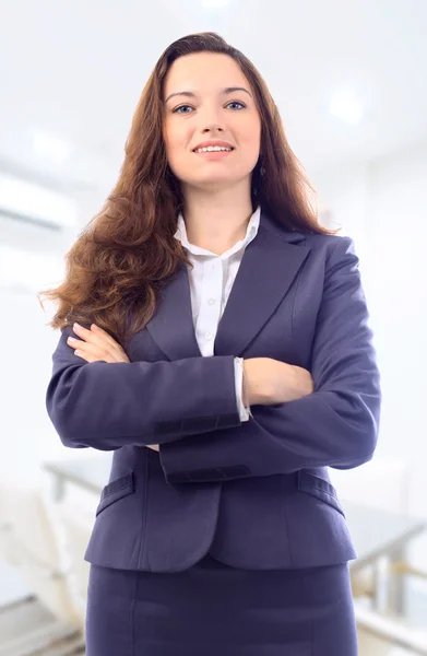 Retrato de una linda joven mujer de negocios sonriendo, en un ambiente de oficina —  Fotos de Stock