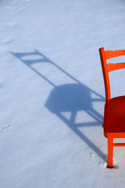 在雪上的橙色椅子阴影 — 图库照片