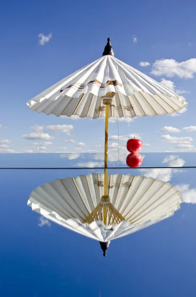Біла парасолька і яблуко на дзеркалі — стокове фото
