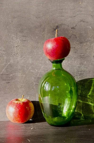 Still-life with bottle and two apples — Stock Photo, Image