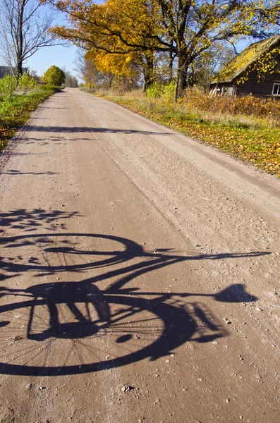 Countryside road with bicycle shadow — Stock Photo, Image